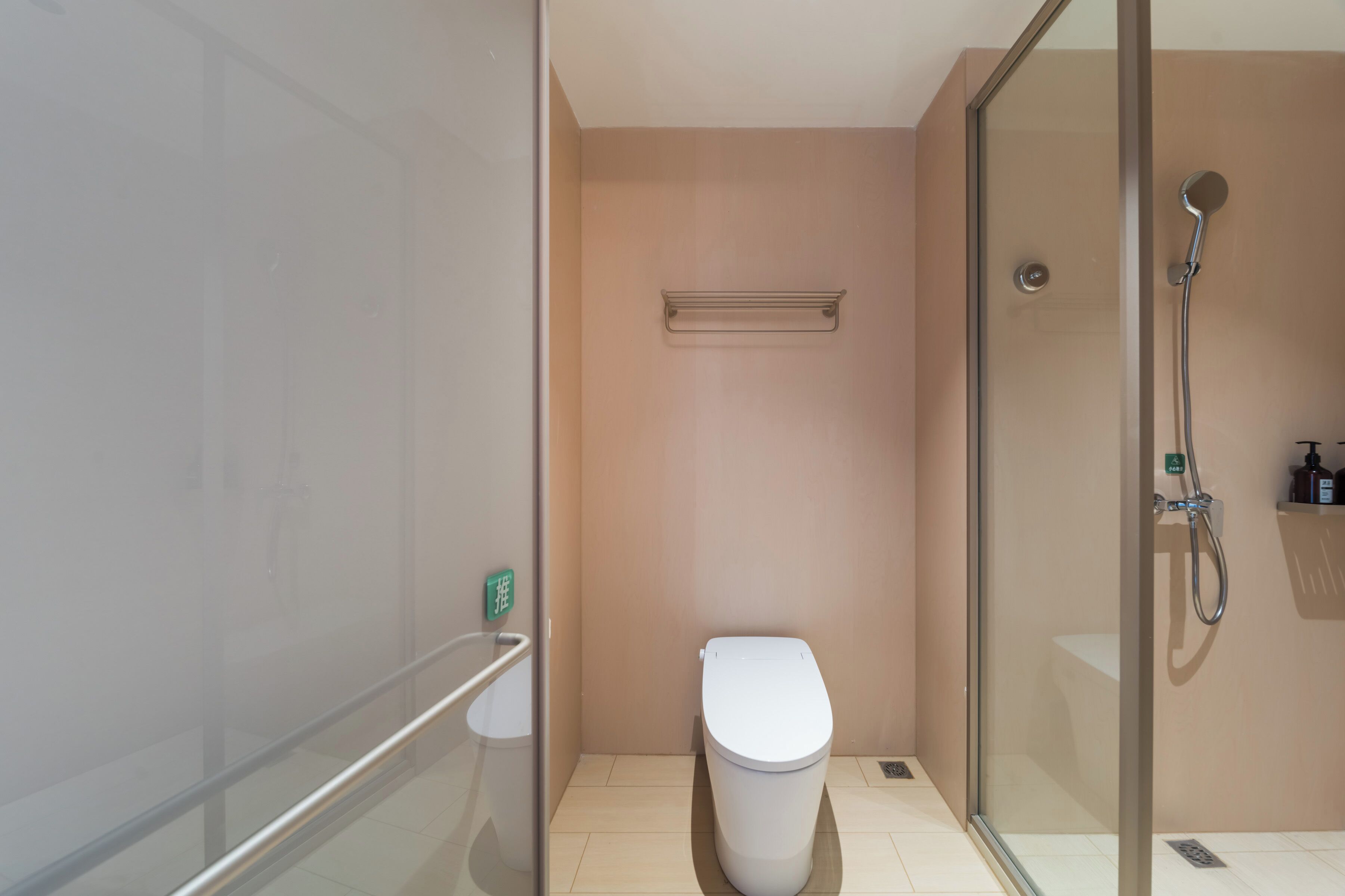 Une salle de bain moderne avec une douche à parois de verre, des toilettes et un porte-serviettes.