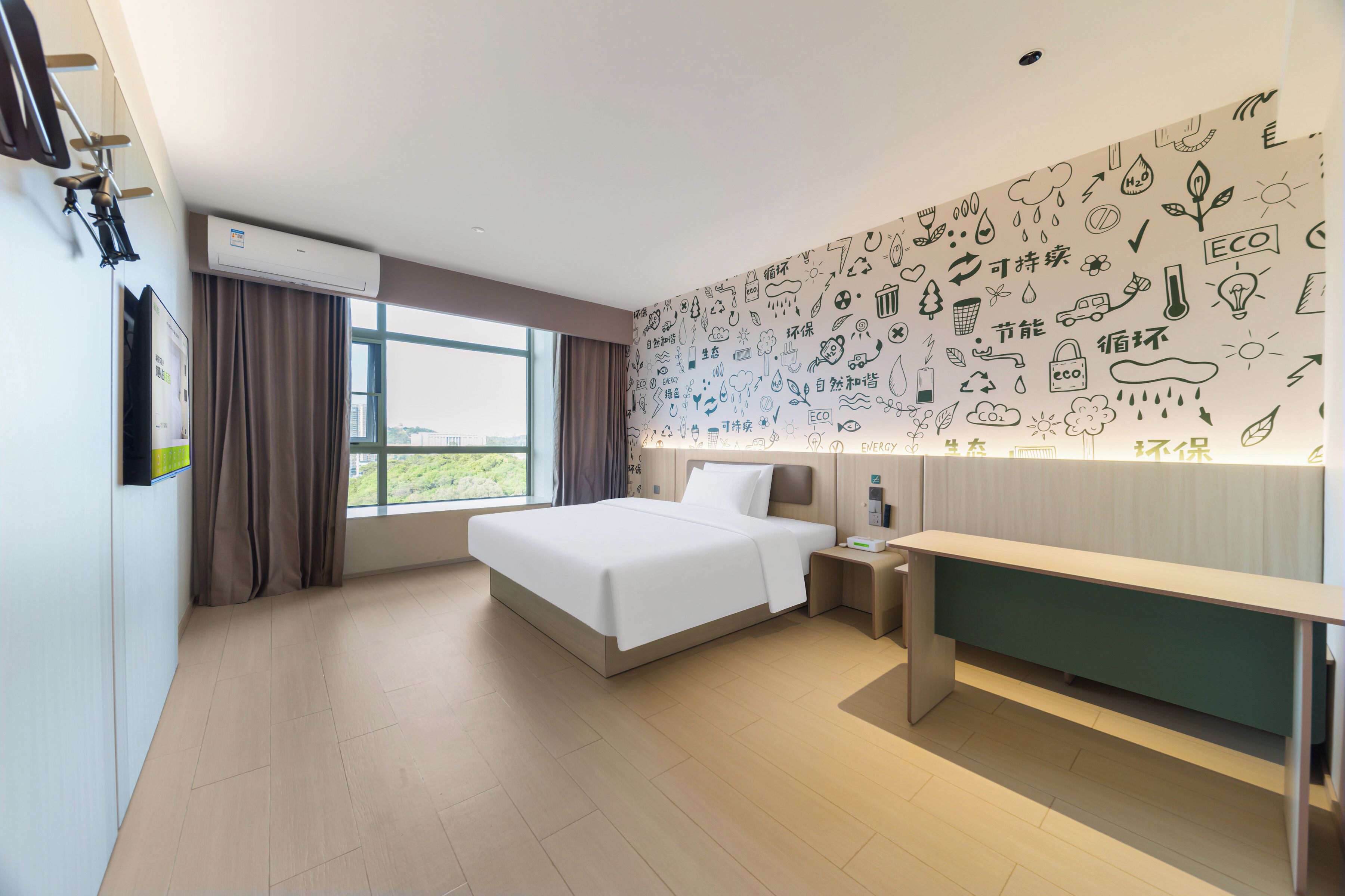 Une chambre d’hôtel équipée d’un lit, d’une table de chevet et d’un mur décoré d’icônes respectueuses de l’environnement.