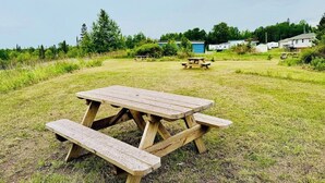Una mesa de picnic en un campo cubierto de césped bajo un cielo despejado.