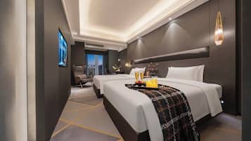 Habitación de hotel con una cama grande, una cama más pequeña, un televisor y vistas a la ciudad.