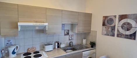 Une cuisine moderne équipée d’un four encastré, d’un évier et d’un coin repas avec une table et des chaises.