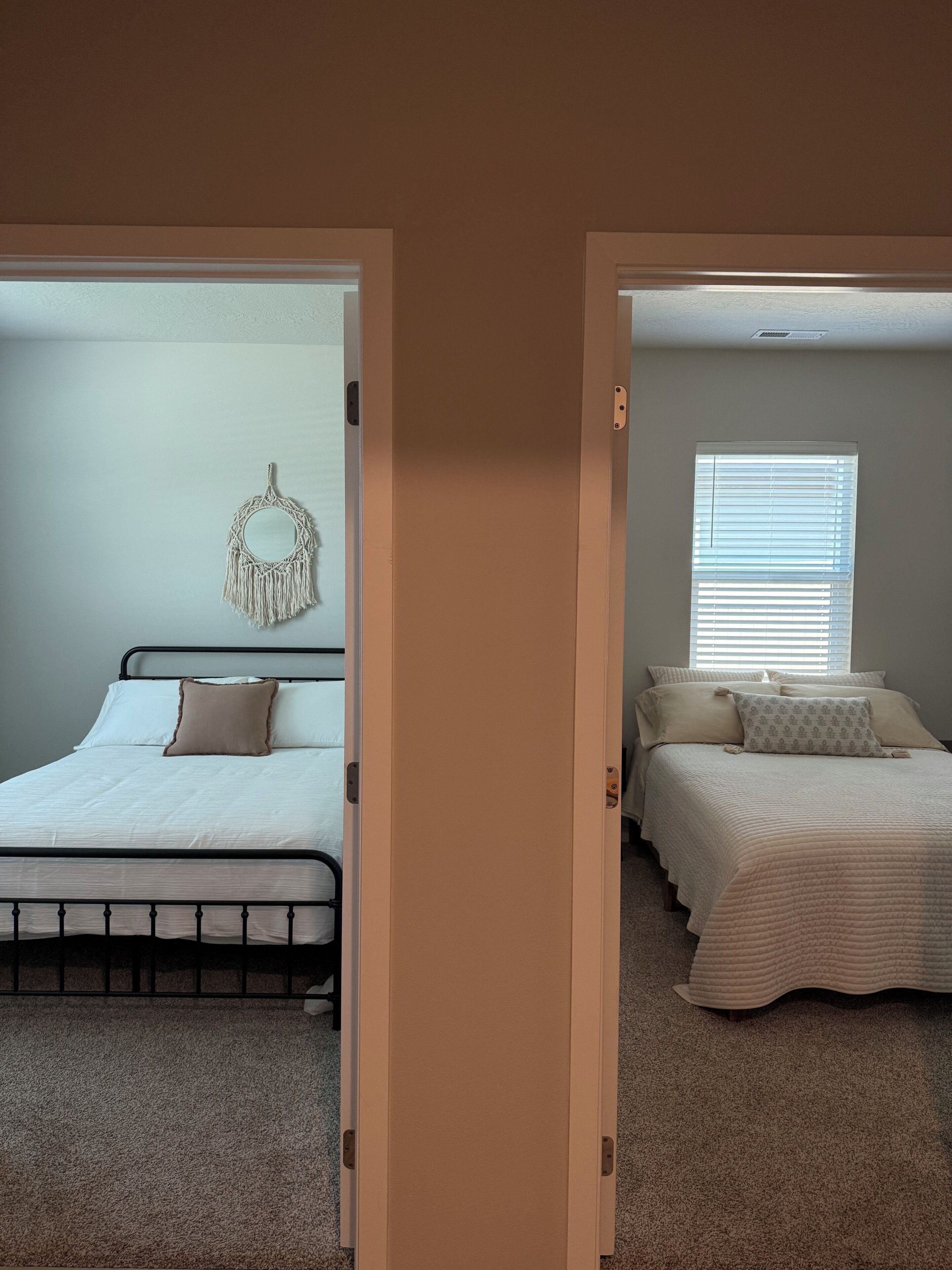 A bedroom with a bed, a wall decoration, and a window with blinds.