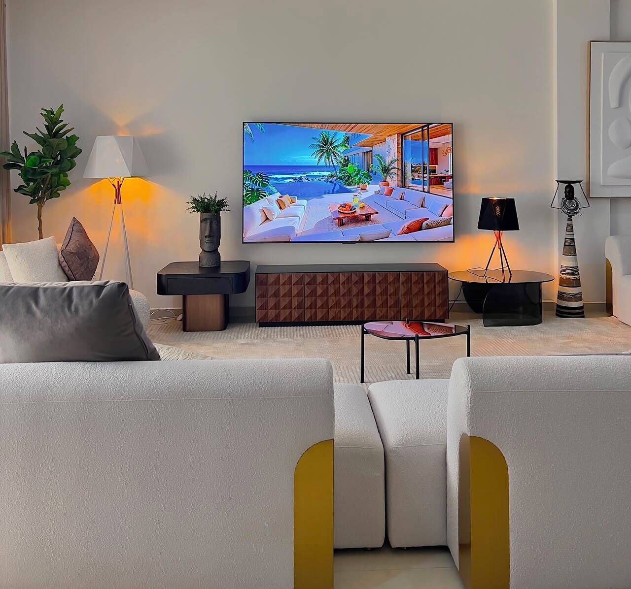 A modern living room with a flat-screen TV, a sofa, a coffee table, and a side table with a lamp.