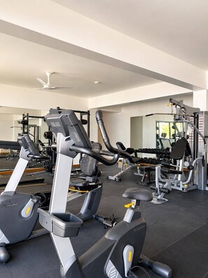 Ein Fitnessstudio mit verschiedenen Trainingsgeräten, darunter Laufbänder und Kraftgeräte.