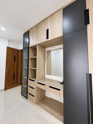 Ein modernes Zimmer mit integriertem Schreibtisch, Regalen und einem Kleiderschrank.