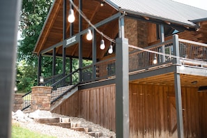 A wooden building with a balcony, a staircase, and a sign that reads 'STORAGE HOUSE'.