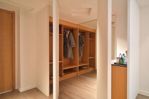 A walk-in closet with wooden shelving, a mirror, and a small countertop with bottles.