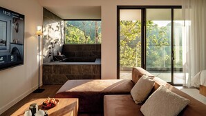 A modern living room with a large window, a fireplace, and a sofa.