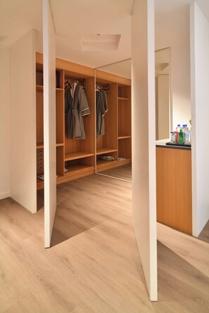 A walk-in closet with wooden shelving and a mirrored closet door.