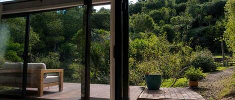 Un patio extérieur moderne avec un banc en bois et une plante en pot.