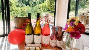 A table with wine bottles and glasses, a balloon, and a floral arrangement.