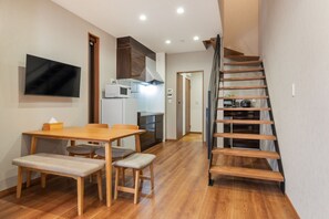 Eine moderne Küche mit Essbereich, Holzboden und einem eingebauten Fernseher.