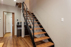Eine moderne Treppe mit Holzdielen und Metallgeländern, die zu einer Zwischenebene führt.