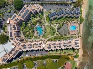 A resort with multiple buildings, swimming pools, and solar panels. - Large 1BR condo, partial ocean view, pool, beach access - Kaanapali Shores 414 (Lahaina)