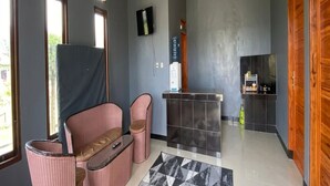 Ein modernes Interieur mit einer Sitzecke, einer Küche und einer Rezeption.
