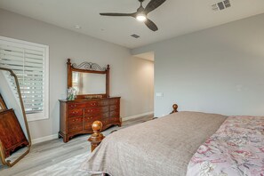 A bedroom with a bed, dresser, mirror, and ceiling fan. - Elegant Home w/ Various Resort Perks in Peoria! (Peoria)
