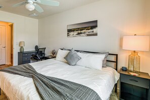 A neatly arranged bedroom with a bed, bedside tables, a lamp, and a wall-mounted artwork. - Community Pools, Golf & More! Home in The Villages (The Villages)