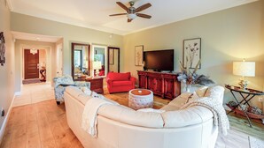 A spacious living room with a large sofa, a red armchair, and a television. - Your Dream Vacation Awaits in Naples! Luxury Condo (Naples)