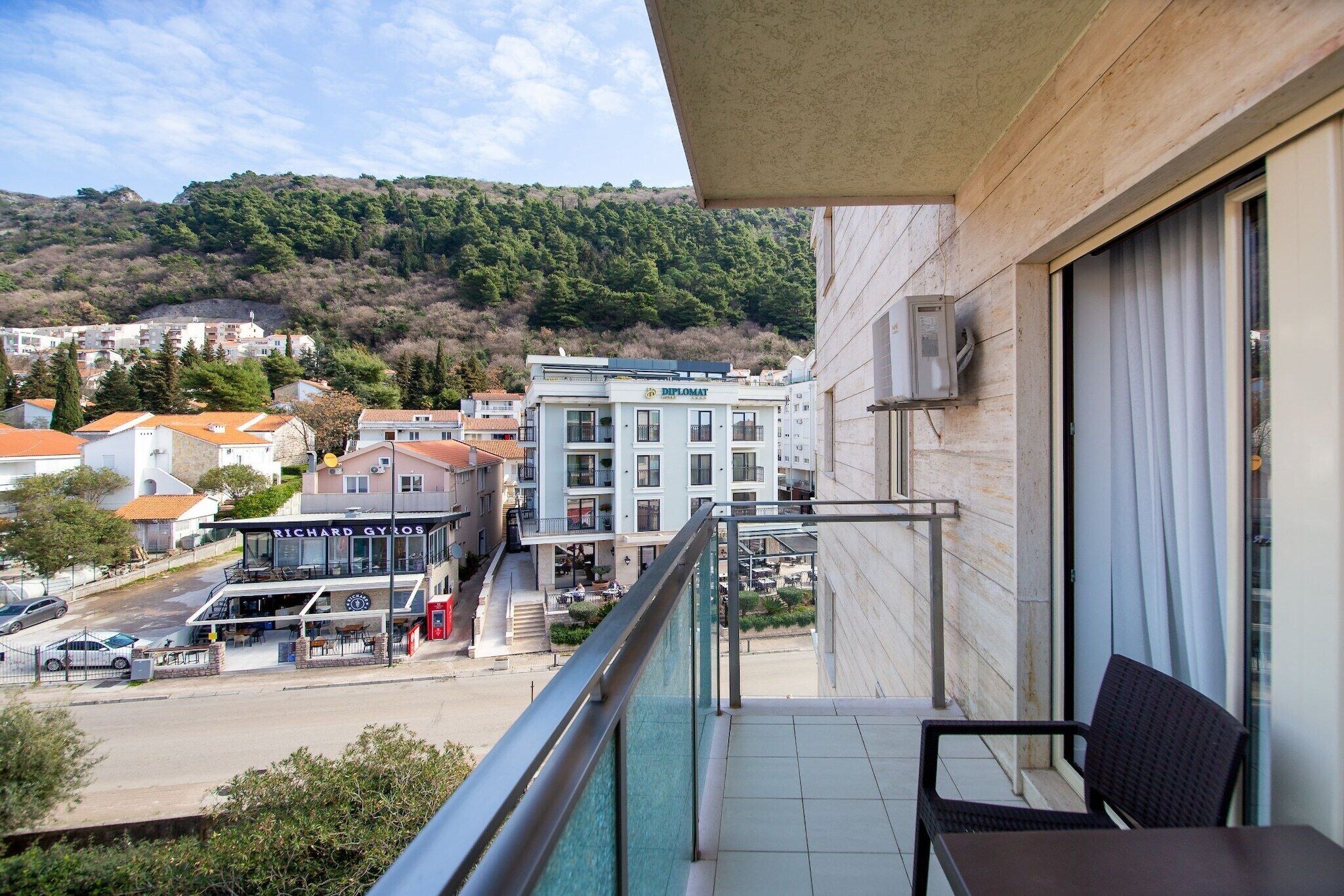 Un balcon donnant sur une ville, un restaurant et un bâtiment avec une enseigne.