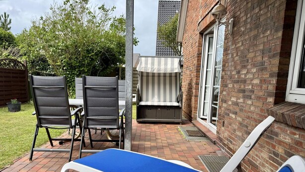A patio with two lounge chairs, a table, and a barbecue grill. - Kampstraße, Apartment 2a - Cozy 2-room vacation apartment with a terrace in a quiet (Sylt)