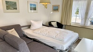 Ett hotellrum med en säng, en soffa, en stol och ett bord.