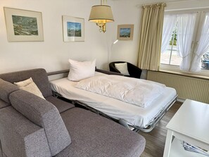 Ein Hotelzimmer mit Bett, Sofa, Sessel und Tisch.