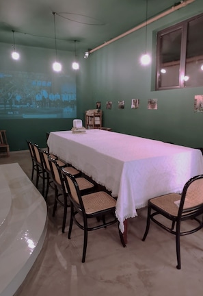 A conference room with a long table, chairs, a projector screen, and a window. - Mogan Mountain Dibeli-in the fields (Huzhou)