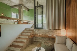 A staircase leading to an upper level, a seating area with a cushion, a small table with a teapot, and a window with curtains. - Mogan Mountain Dibeli-in the fields (Huzhou)