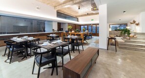 A spacious dining area with multiple tables and chairs, a long bench, and a view of the kitchen through a glass wall. - Mogan Mountain Dibeli-in the fields (Huzhou)
