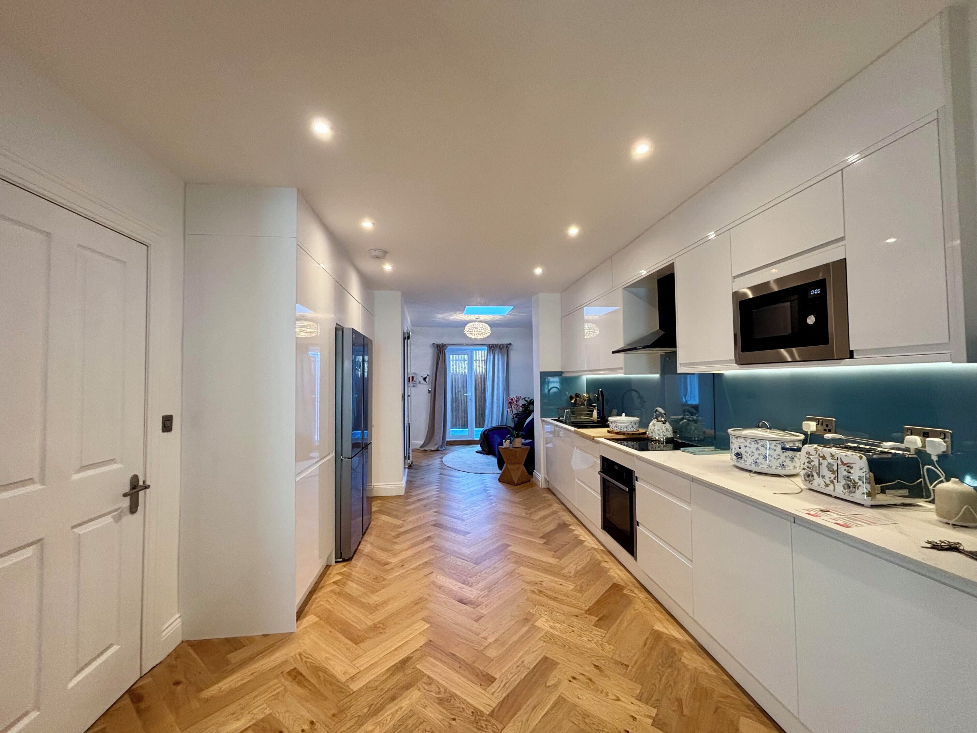 A modern kitchen with white cabinetry, a microwave, and a dishwasher.