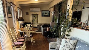 A cozy living room with a sofa, chairs, a coffee table, and a large plant.