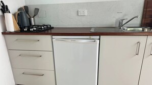 A kitchen with a built-in dishwasher, a sink, and a countertop with kitchen utensils.