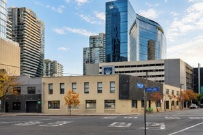 A city street with modern buildings, including a prominent glass skyscraper. - Southbank 2BR 2Bath | Free Parking & Balcony (Southbank)