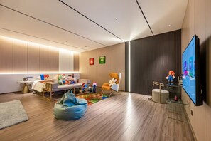 Ein modernes Wohnzimmer mit Flachbildfernseher, einer Couch, einem Sitzsack und einem Couchtisch.