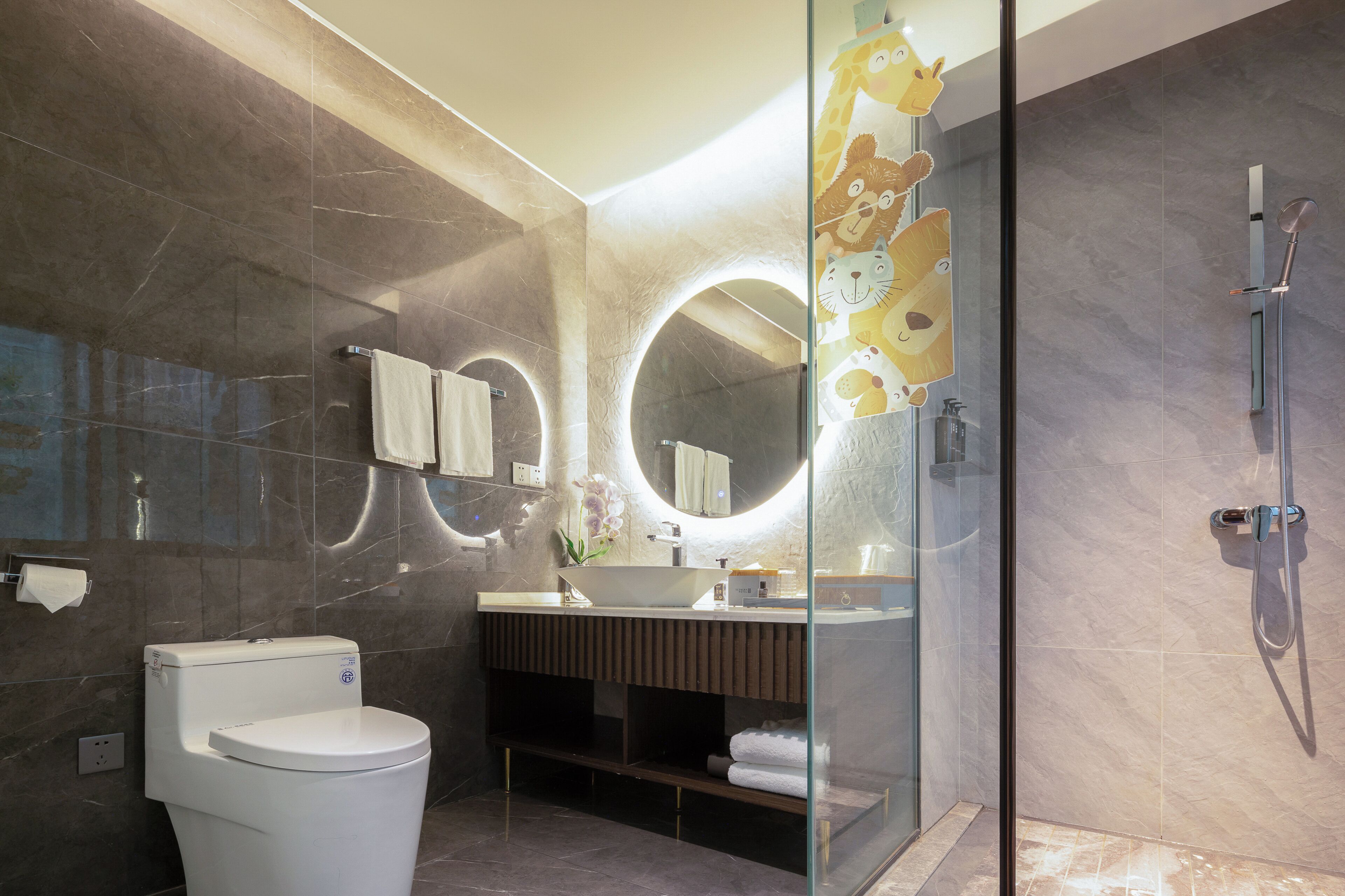 A modern bathroom with a toilet, sink, and shower.