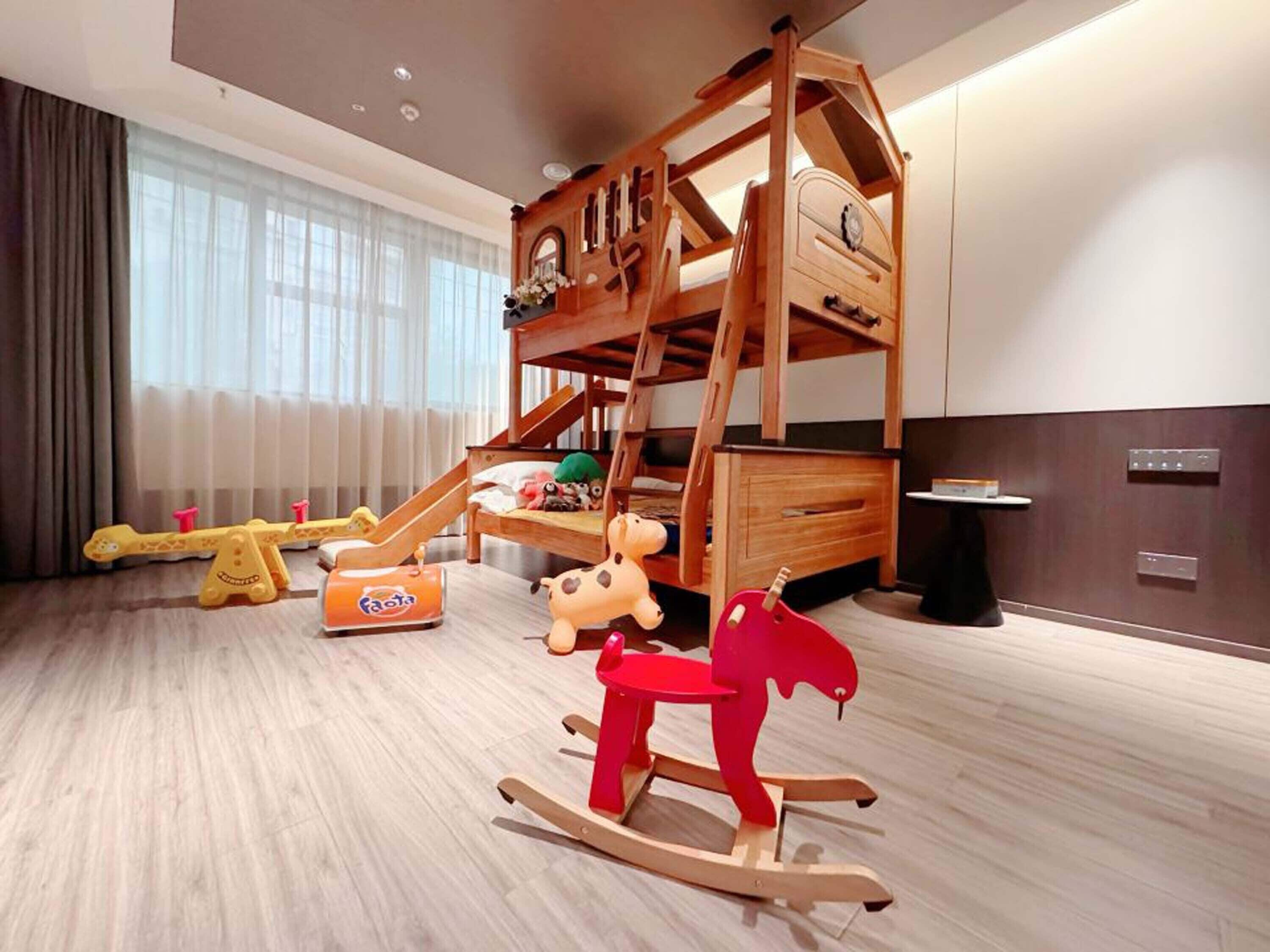 A children's play area with a bunk bed, a seesaw, and a rocking horse.