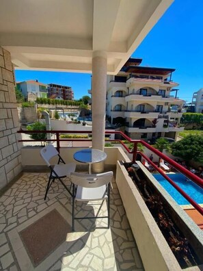 A balcony with a pool, a table, and chairs. - H Kleopatra (Ulcinj)