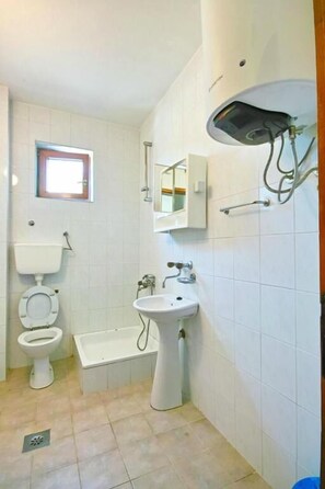 A bathroom with a toilet, sink, and bathtub. - H Kleopatra (Ulcinj)