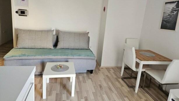 Ein stilvolles Wohnzimmer mit einer Couch, einem kleinen Tisch und einem Holznachttisch.