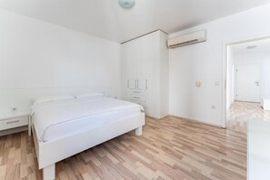 A bedroom with a bed, a wardrobe, a nightstand, and an air conditioning unit. - Barbati (Vidalići)