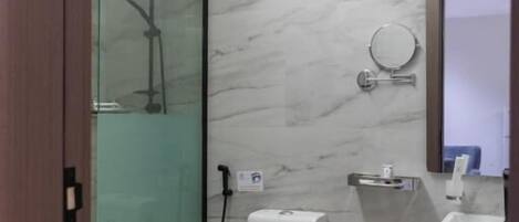 A modern bathroom with a glass shower enclosure, a toilet, and a sink.