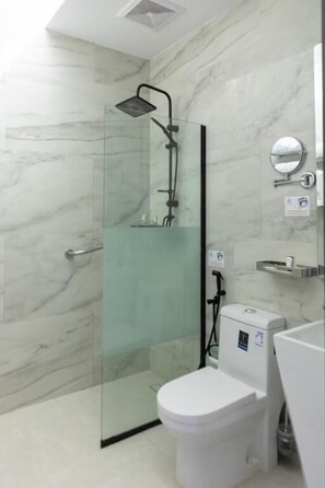 A modern bathroom with a glass-enclosed shower, a white toilet, and a marble wall. - HOLIDAY AL KHALEEJ HOTEL AL FALAH (AL RIYADH)