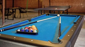 Un tavolo da biliardo con una serie di palle e un bastone da gioco.