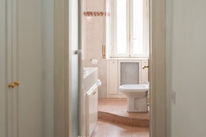 Une salle de bain avec des toilettes, un bidet et une fenêtre.