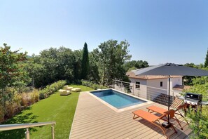 A backyard with a swimming pool, outdoor furniture, and a barbecue area. - Villa Nova (Ventabren)