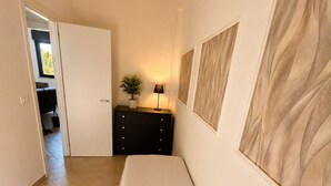 A bedroom with a bed, a dresser, a lamp, and a potted plant. - At Cherie's House! Nettuno! (Nettuno)