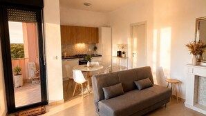 A modern living room with a sofa, a dining area, and a kitchen. - At Cherie's House! Nettuno! (Nettuno)