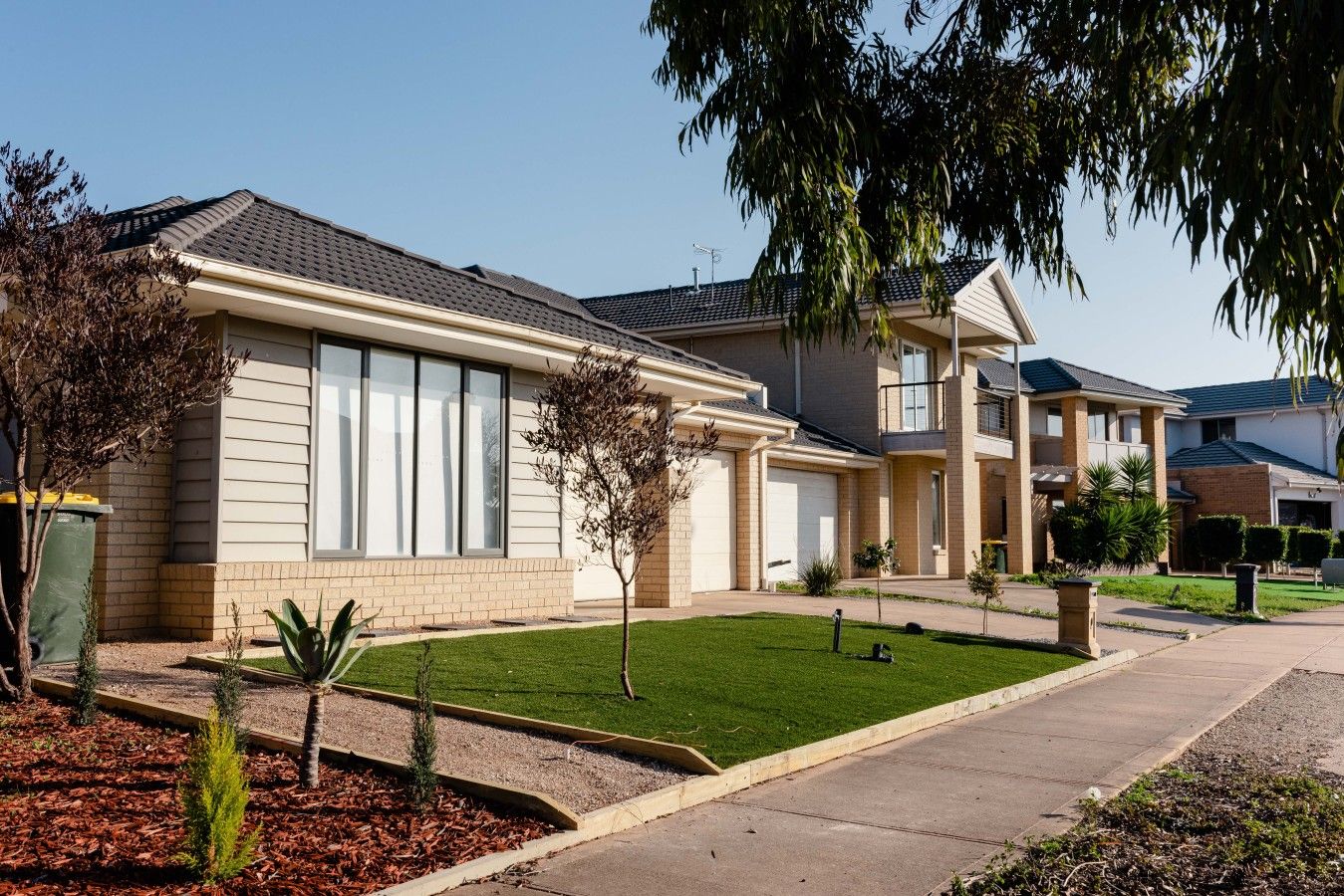A residential building with a front yard, a garage, and a driveway.