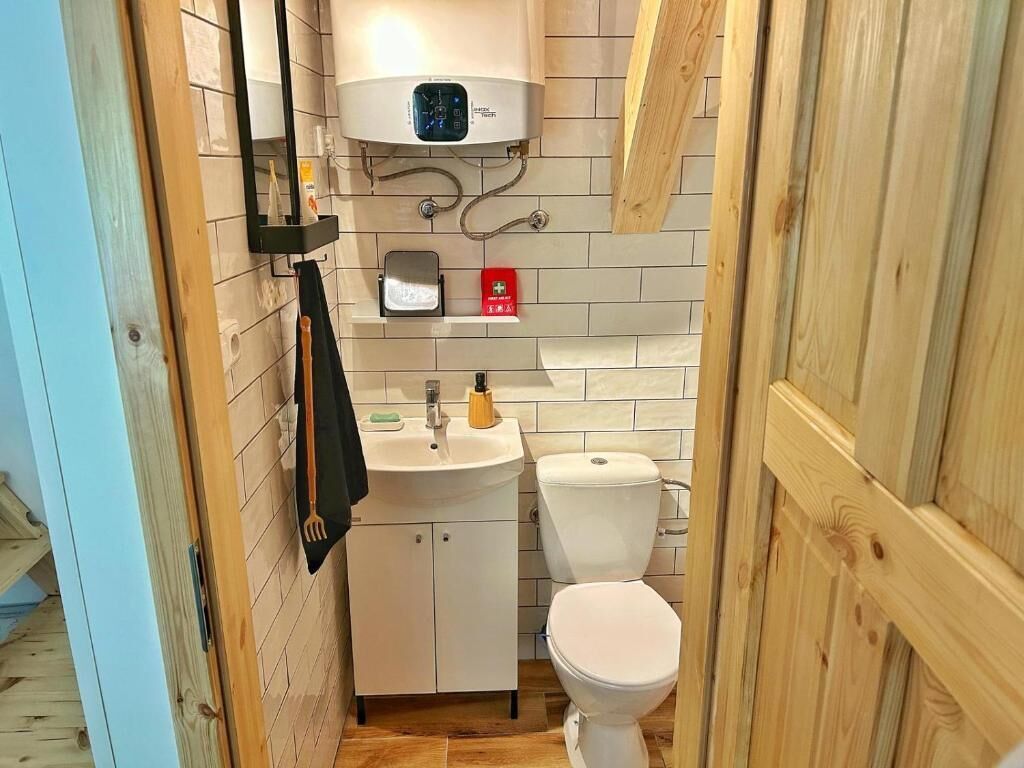 Baño pequeño con inodoro, lavamanos y un calentador de pared.