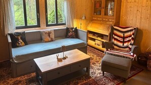 Una sala acogedora con un sofá, un sillón y un aparador.